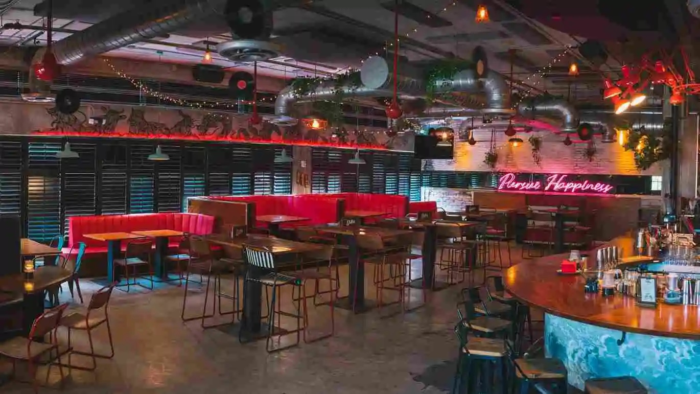 50's style interior with neon signs, red leather horseshoe booths and a bar area
