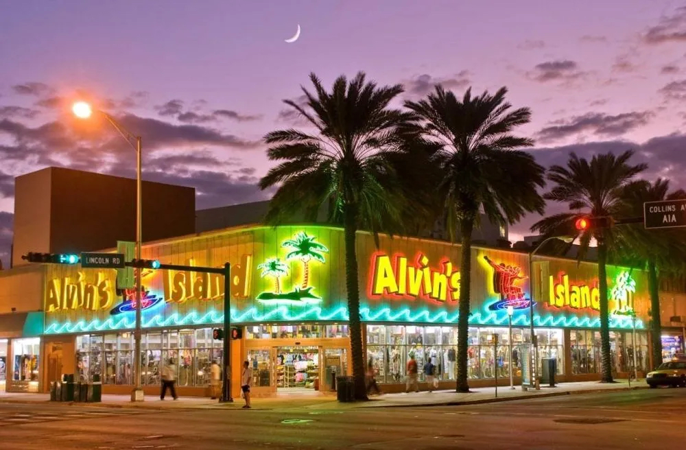 Exterior view of Alvin's Island building buzzing with neon signage that wraps around the upper walls